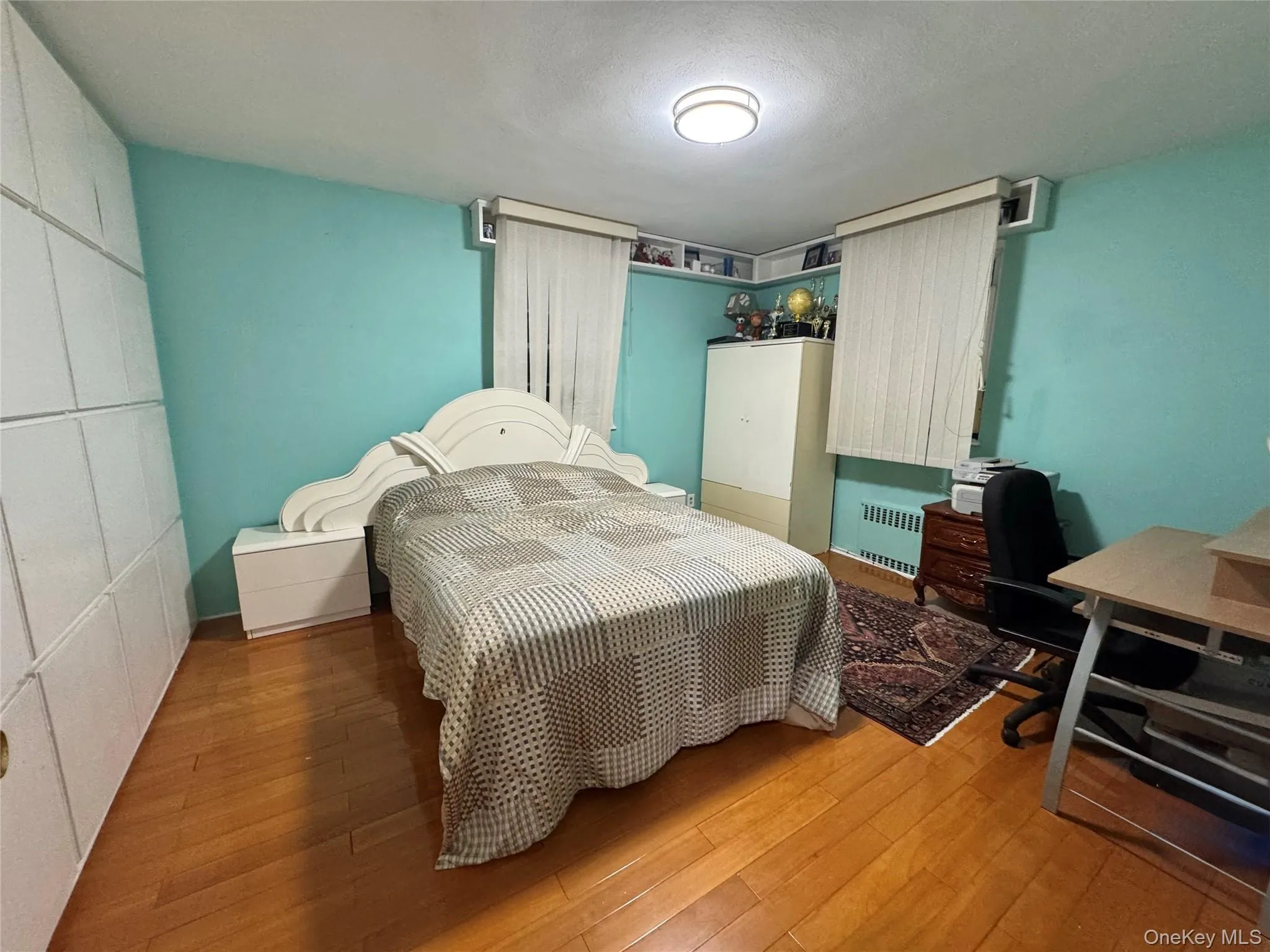 Hardwood flooring, built-in shelving, and a flush-mount ceiling light Hardwood flooring, built-in shelving, and a flush-mount ceiling light