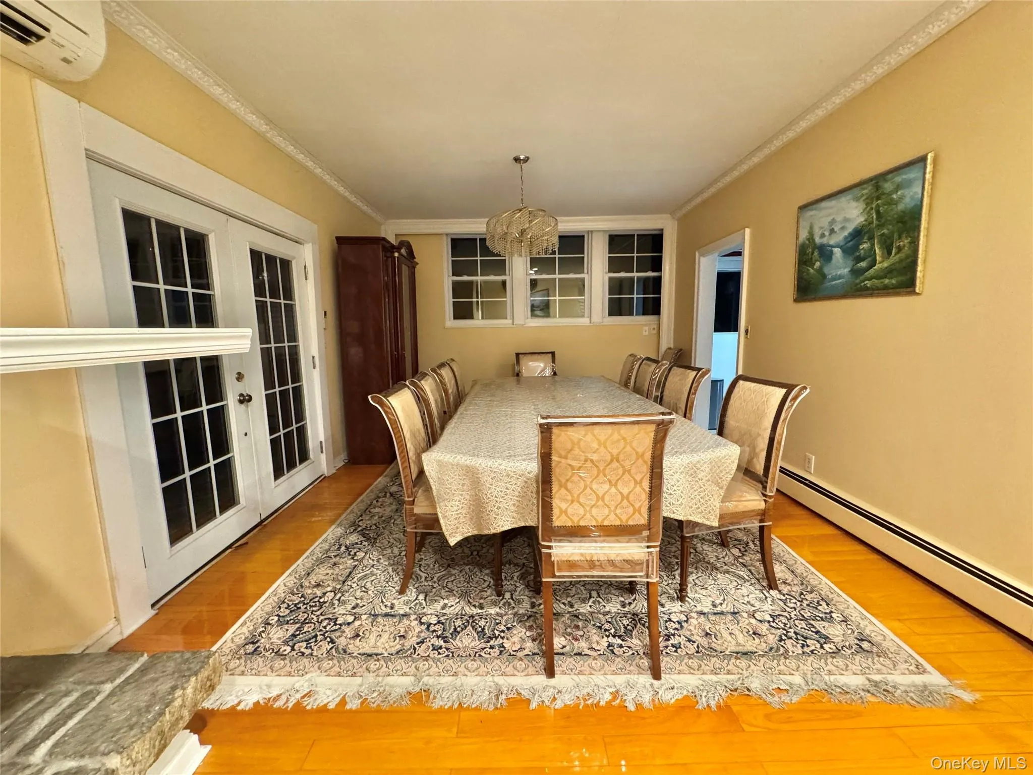 Hardwood flooring, crown molding, French doors with glass panels, multiple windows, and a built-in light fixture Hardwood flooring, crown molding, French doors with glass panels, multiple windows, and a built-in light fixture