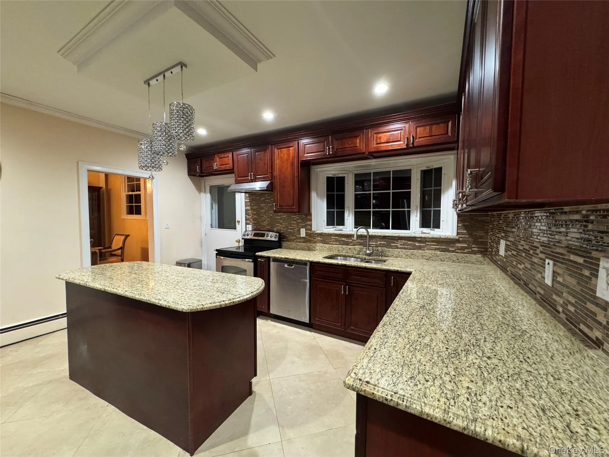 Kitchen featuring wood-finish cabinetry, light-toned tile flooring, granite countertops, and a tile backsplash Kitchen featuring wood-finish cabinetry, light-toned tile flooring, granite countertops, and a tile backsplash