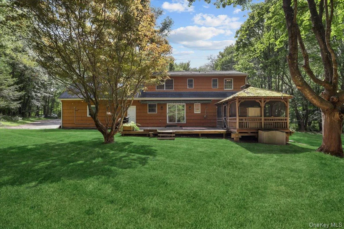Expansive green lawn with mature trees and a multi-level wood deck Expansive green lawn with mature trees and a multi-level wood deck