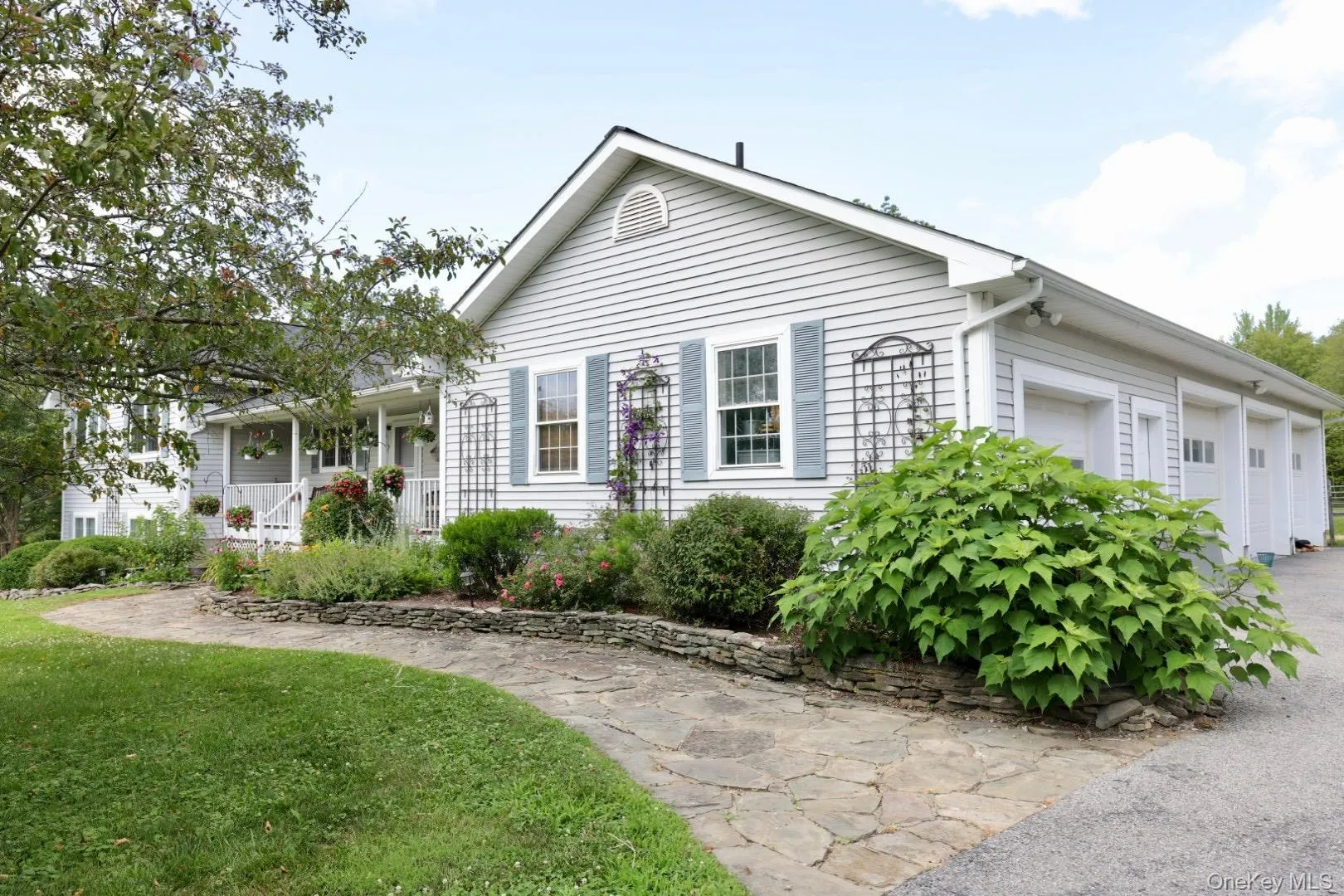 View of front facade with covered porch, a front lawn, and an attached garage View of front facade with covered porch, a front lawn, and an attached garage