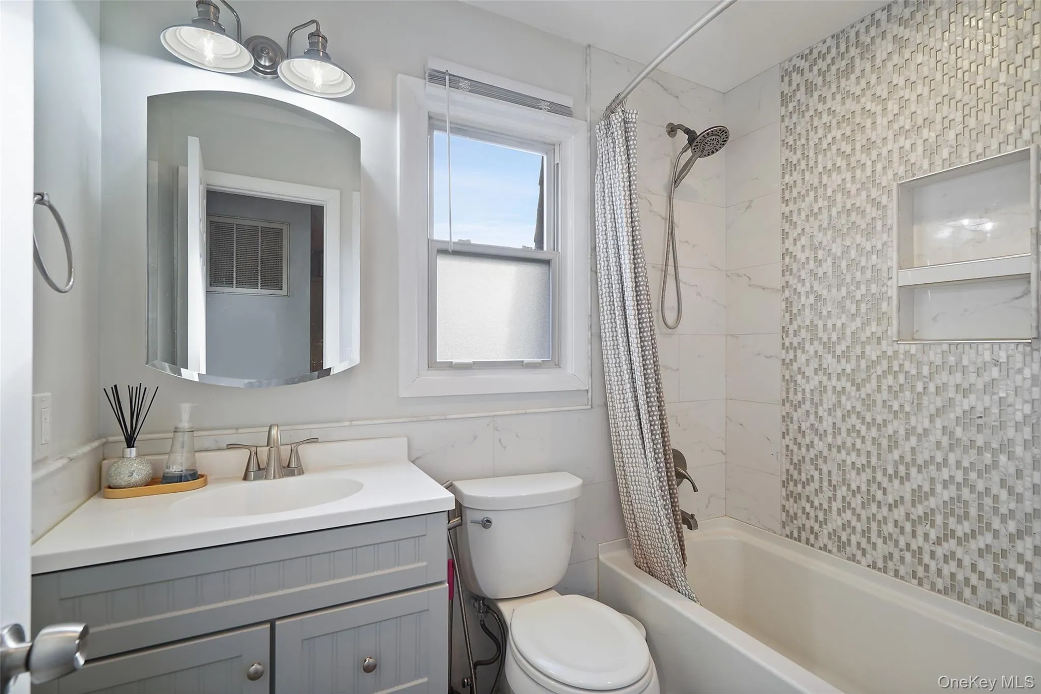 Full bathroom featuring vanity, shower / bathtub combination with curtain, and toilet Full bathroom featuring vanity, shower / bathtub combination with curtain, and toilet
