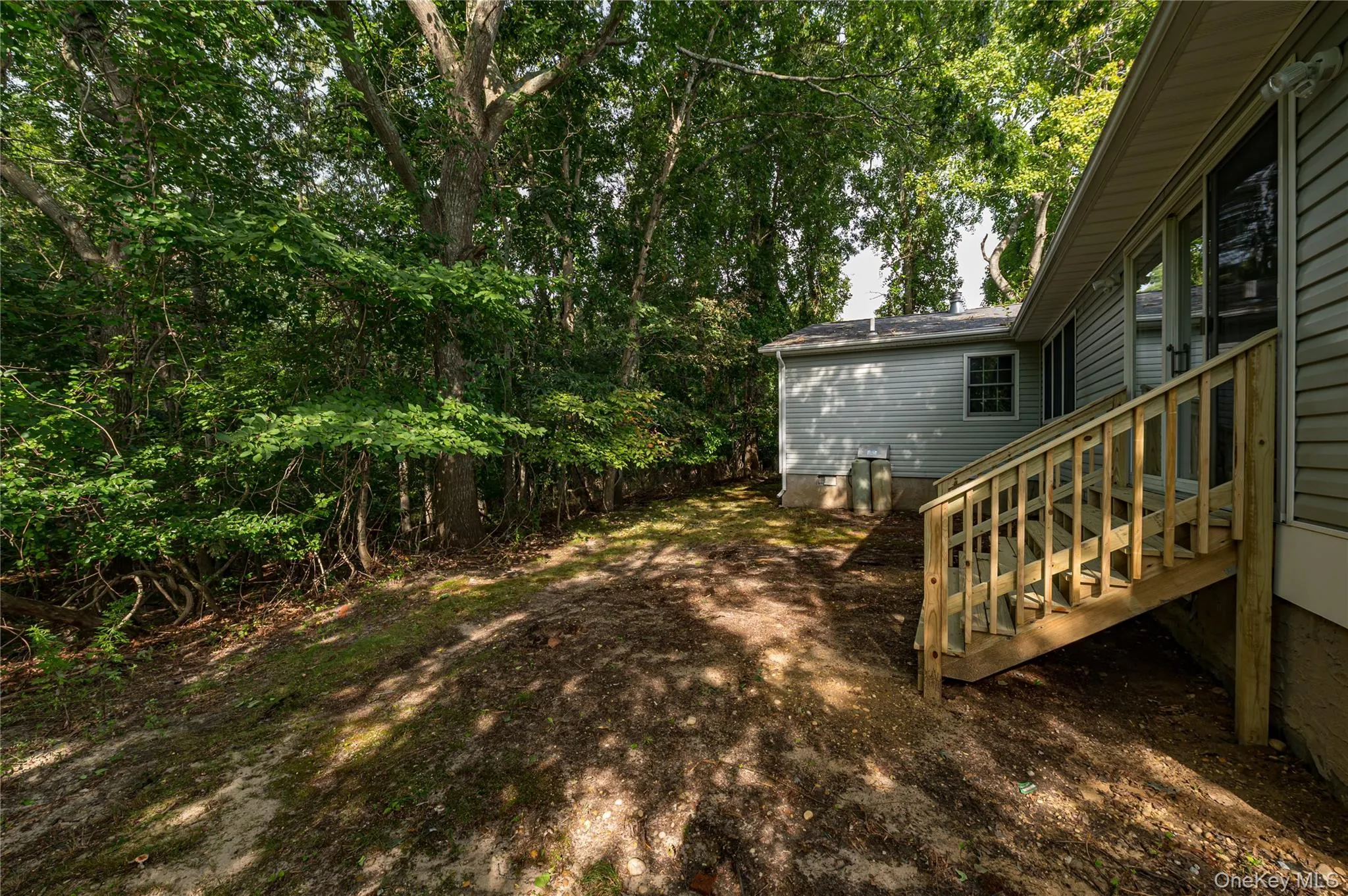 Exterior siding with a new wooden staircase leading to a sliding glass door Exterior siding with a new wooden staircase leading to a sliding glass door