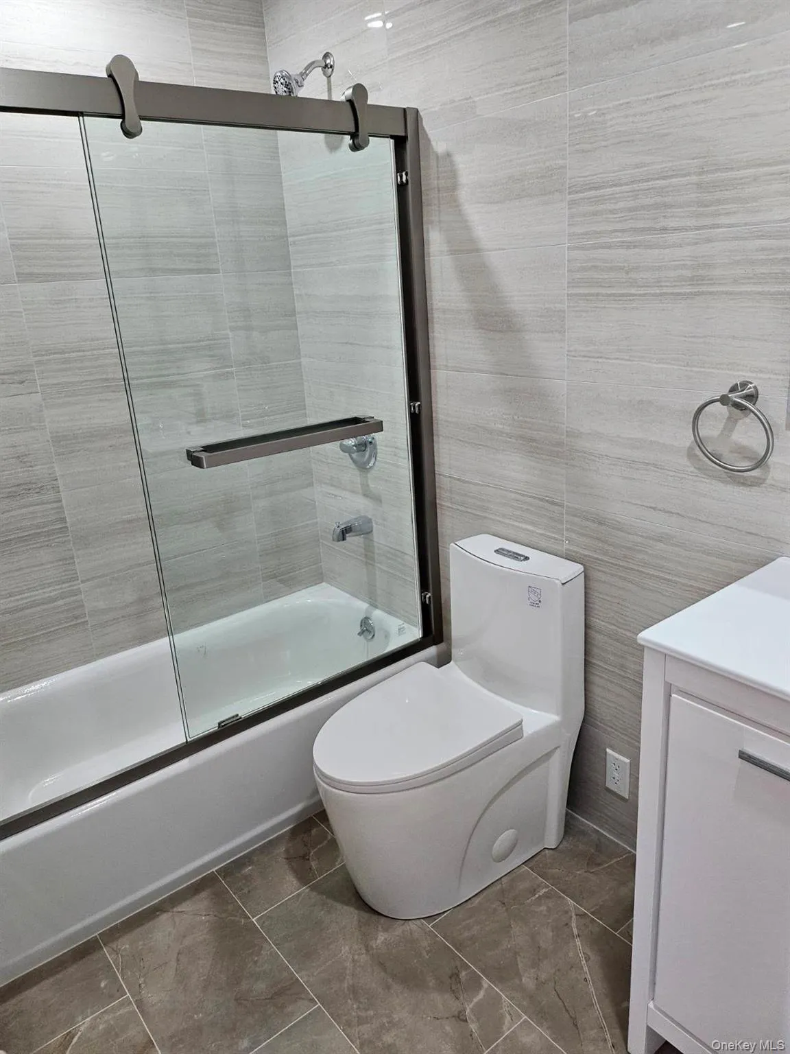 Bathroom with vanity, enclosed tub / shower combo, and tile walls Bathroom with vanity, enclosed tub / shower combo, and tile walls