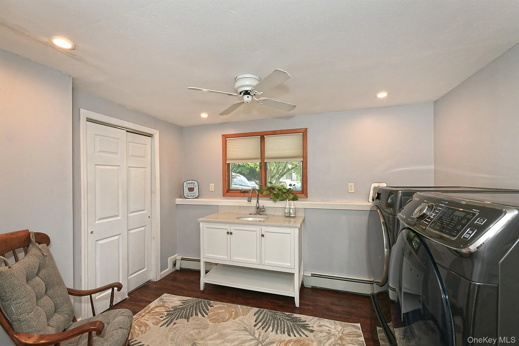 Recessed lighting, wood-finish flooring, white vanity with integrated sink, natural wood window trim, and white bi-fold closet doors. Doubling as a laundry room Recessed lighting, wood-finish flooring, white vanity with integrated sink, natural wood window trim, and white bi-fold closet doors. Doubling as a laundry room