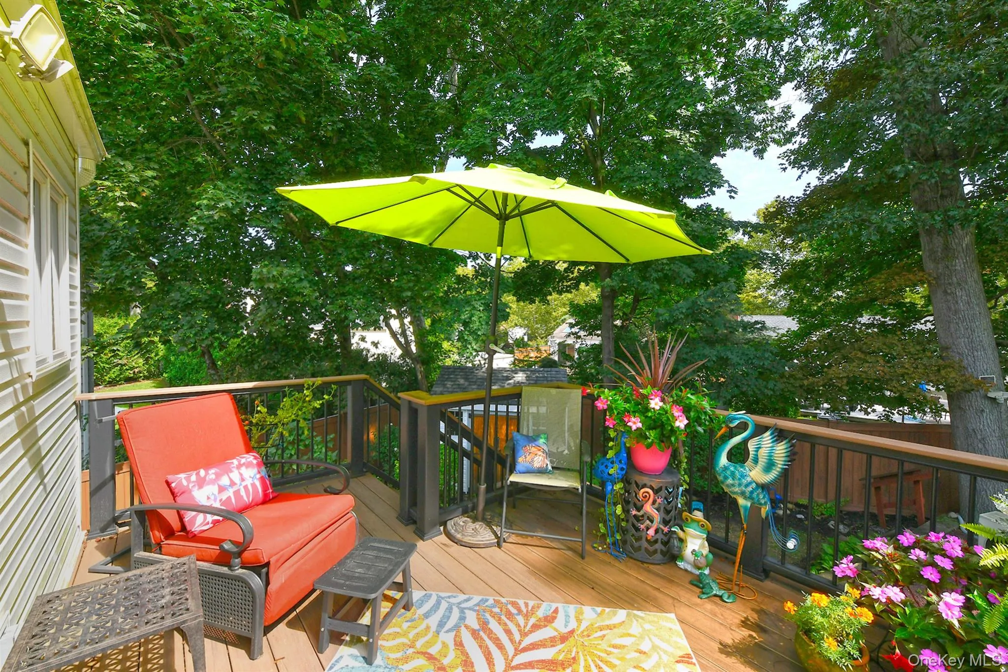 Wood-finish deck with dark-toned railing, framed by mature trees Wood-finish deck with dark-toned railing, framed by mature trees