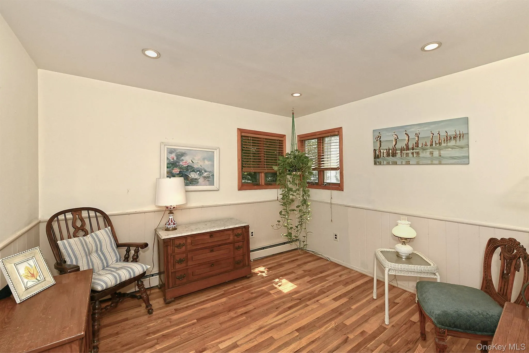 Recessed ceiling lighting, wood-finish flooring, wood window frames, panel wainscoting, and white wall finishes Recessed ceiling lighting, wood-finish flooring, wood window frames, panel wainscoting, and white wall finishes
