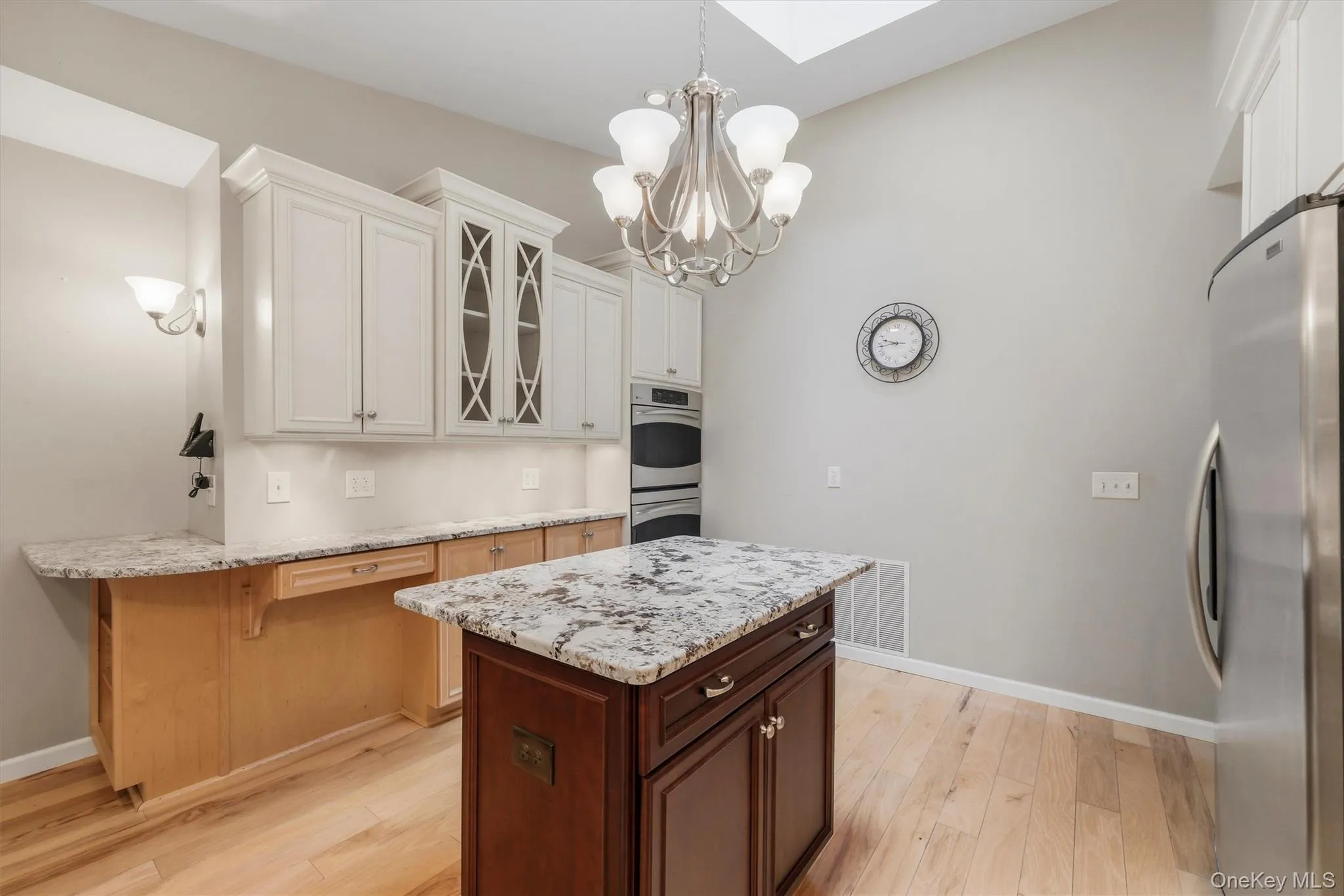 Custom kitchen with center island and snack bar, stainless appliances including double ovens, granite counters and wood floors Custom kitchen with center island and snack bar, stainless appliances including double ovens, granite counters and wood floors