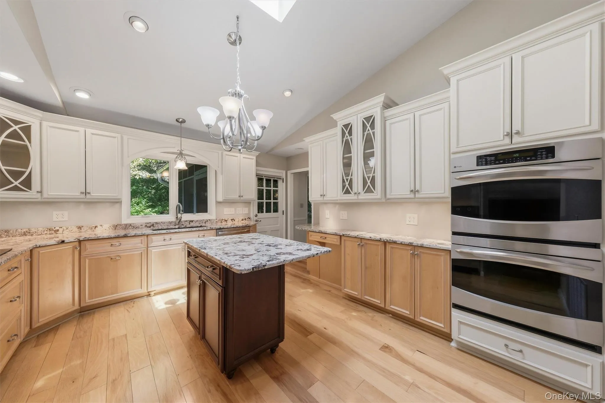 Custom kitchen with center island and snack bar, stainless appliances including double ovens, granite counters and wood floors Custom kitchen with center island and snack bar, stainless appliances including double ovens, granite counters and wood floors