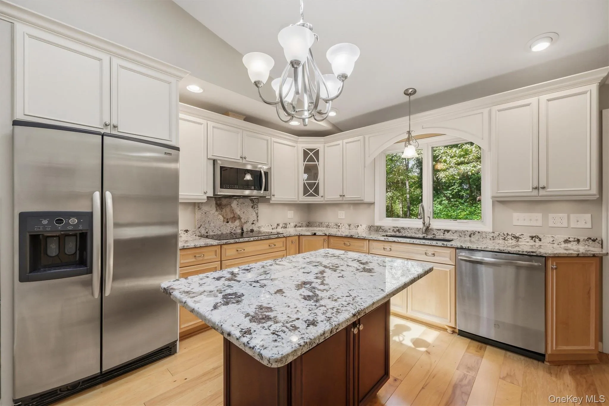 Custom kitchen with center island and snack bar, stainless appliances including double ovens, granite counters and wood floors Custom kitchen with center island and snack bar, stainless appliances including double ovens, granite counters and wood floors