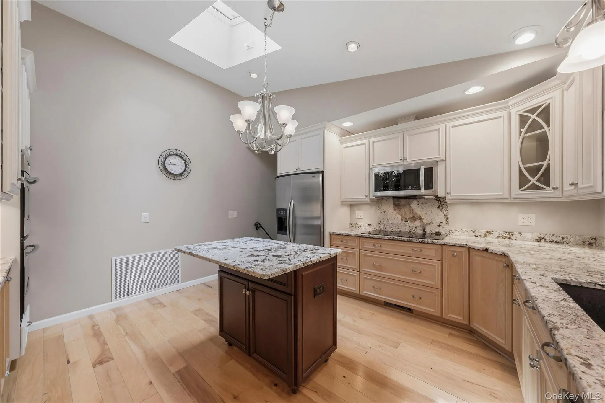 Custom kitchen with center island and snack bar, stainless appliances including double ovens, granite counters and wood floors Custom kitchen with center island and snack bar, stainless appliances including double ovens, granite counters and wood floors