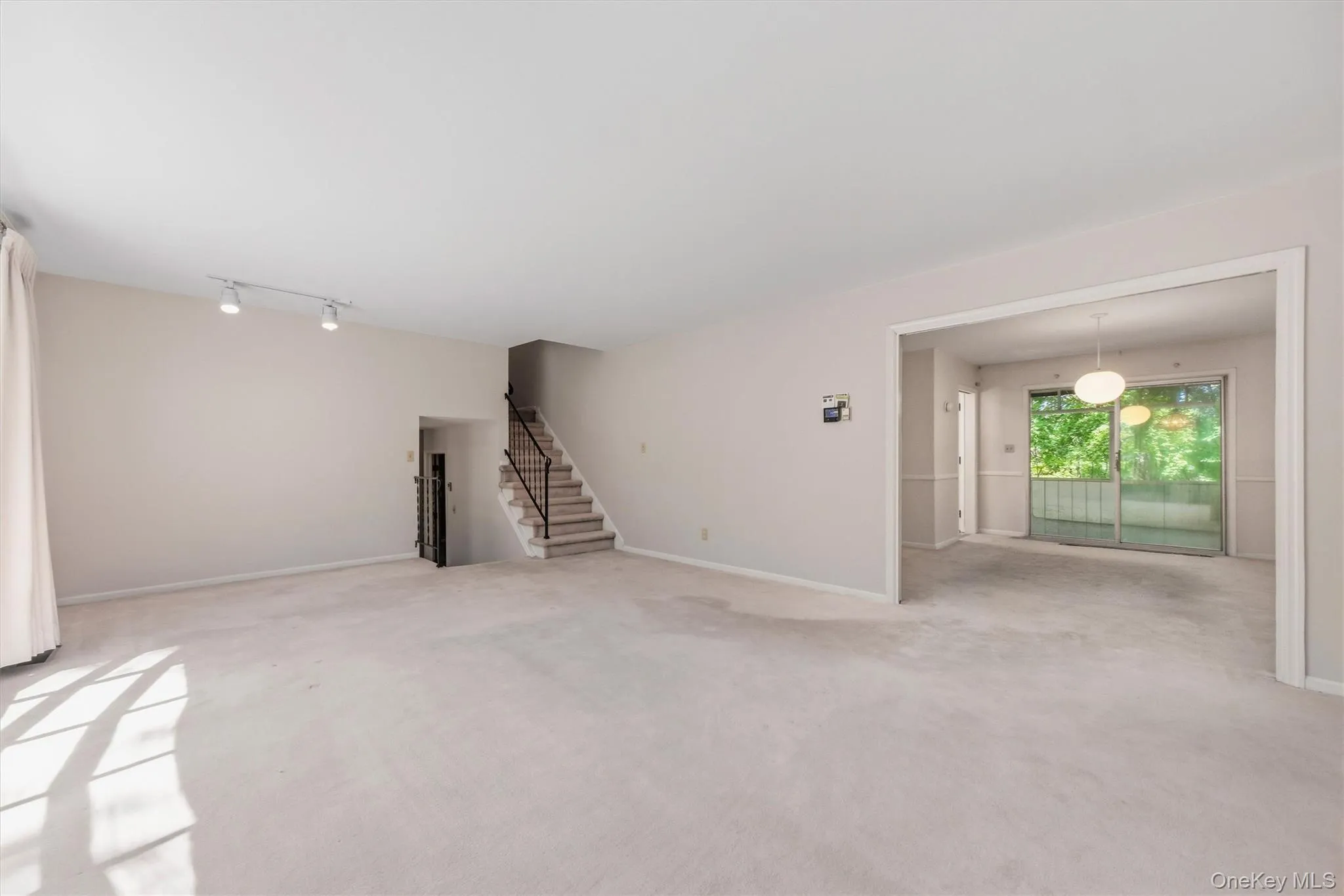 Expansive formal living room with large bow window and wood burning fireplace. Hardwood under carpet. Expansive formal living room with large bow window and wood burning fireplace. Hardwood under carpet.