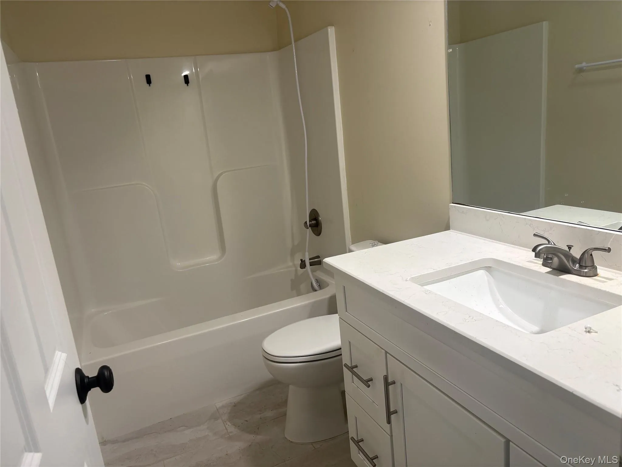 White vanity with a light-colored countertop, integrated sink, and brushed nickel faucet White vanity with a light-colored countertop, integrated sink, and brushed nickel faucet
