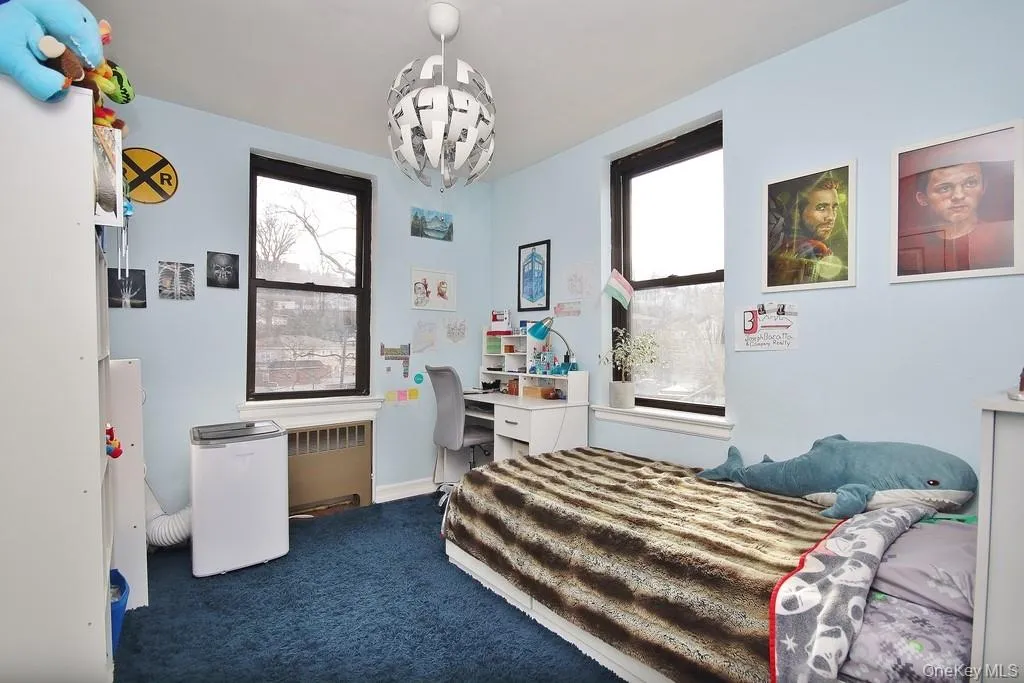 Carpeted room featuring multiple windows with dark trim and a ceiling-mounted light fixture Carpeted room featuring multiple windows with dark trim and a ceiling-mounted light fixture