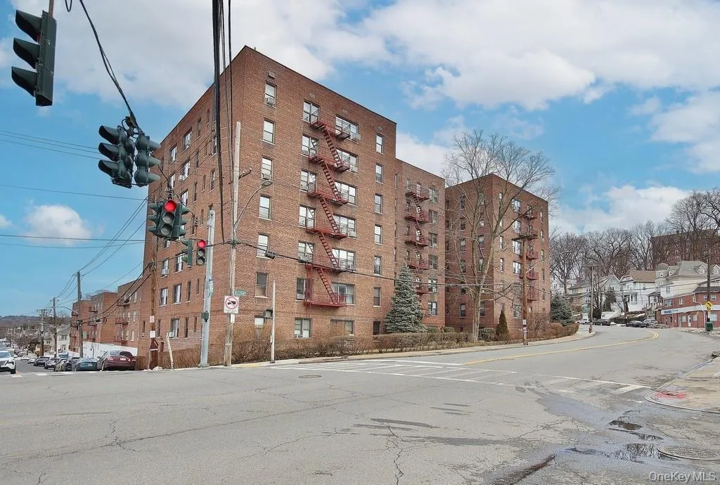 Brick facade building with multiple levels of windows and exterior fire escapes Brick facade building with multiple levels of windows and exterior fire escapes