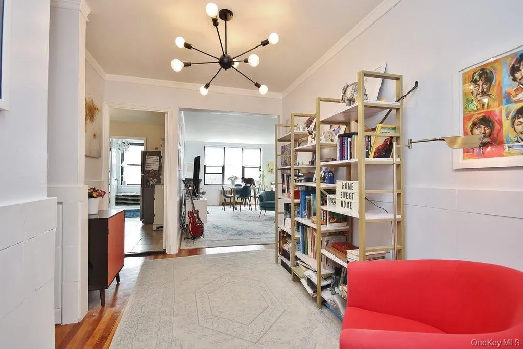 Recessed entry with wood-finish flooring, modern chandelier, and built-in shelving Recessed entry with wood-finish flooring, modern chandelier, and built-in shelving