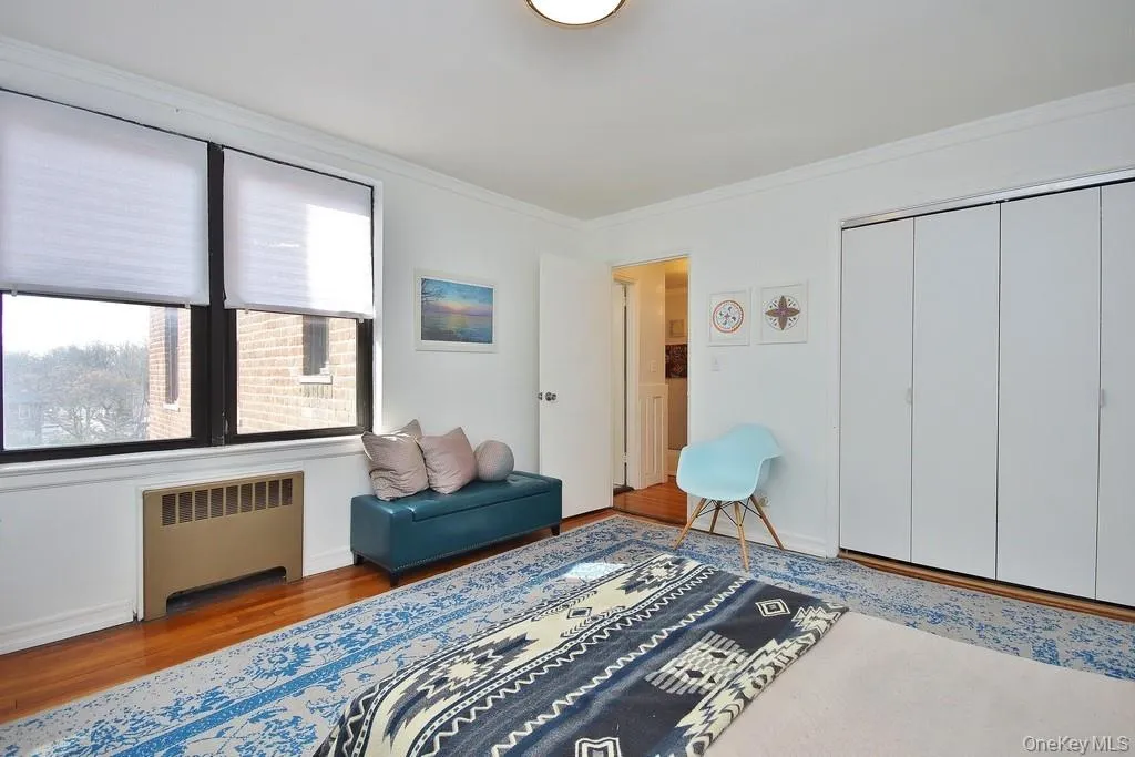 Hardwood flooring, white walls, crown molding, double window, and bi-fold closet doors Hardwood flooring, white walls, crown molding, double window, and bi-fold closet doors