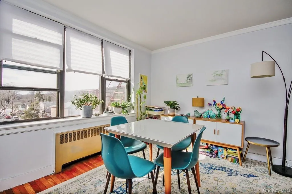 Hardwood flooring, light gray wall color, crown molding, and large windows with blinds Hardwood flooring, light gray wall color, crown molding, and large windows with blinds