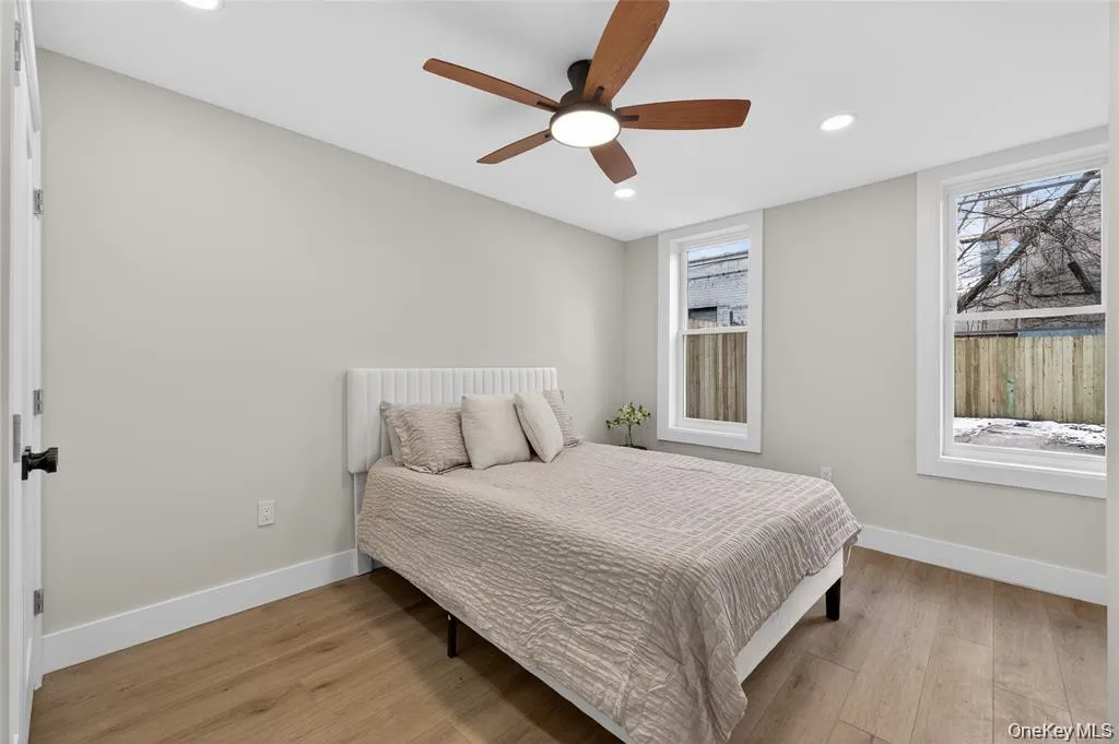 Wood-finish flooring, recessed lighting, and a ceiling fan with integrated lighting Wood-finish flooring, recessed lighting, and a ceiling fan with integrated lighting