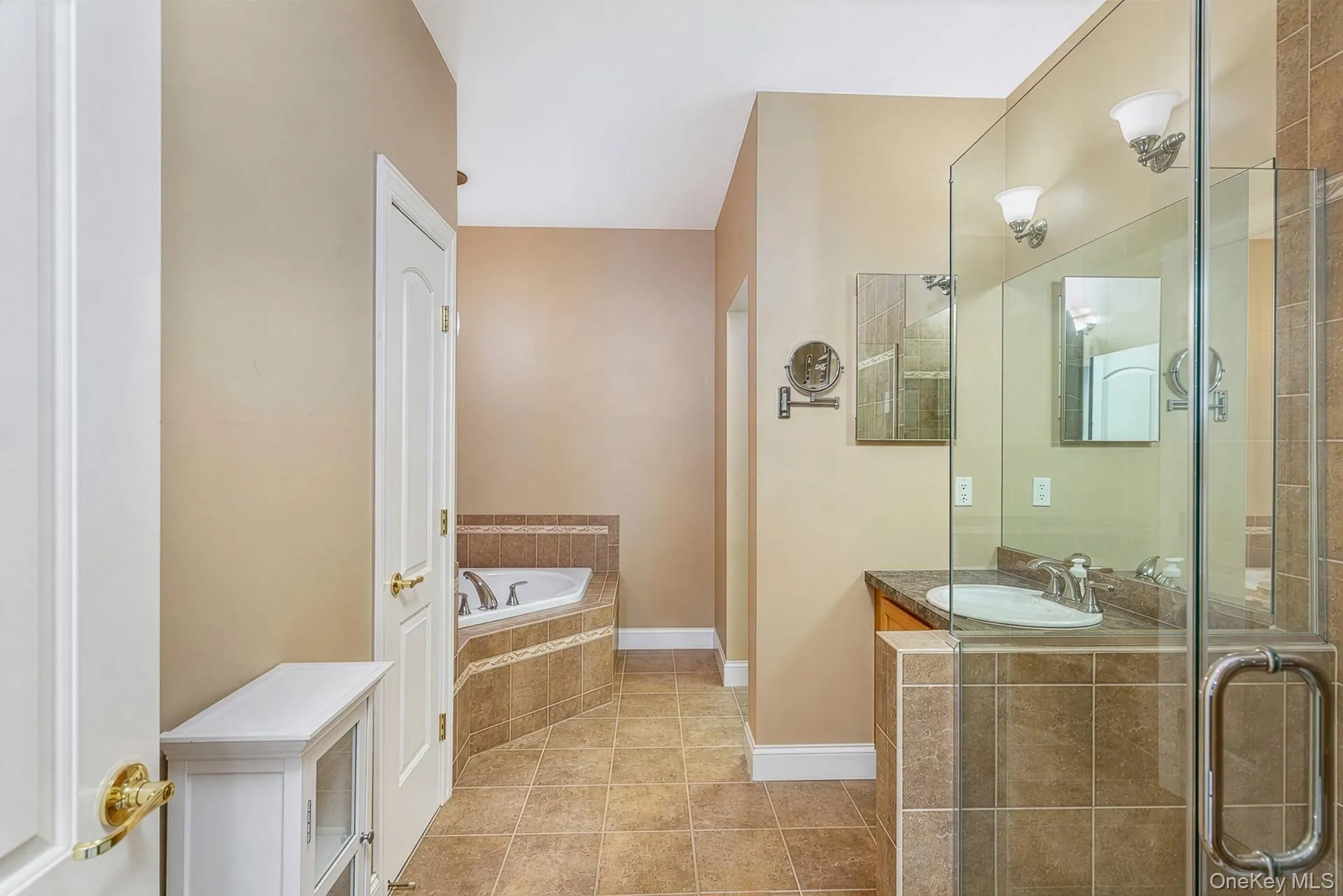 Glass shower enclosure, large vanity, corner soaking tub, and tiled flooring Glass shower enclosure, large vanity, corner soaking tub, and tiled flooring