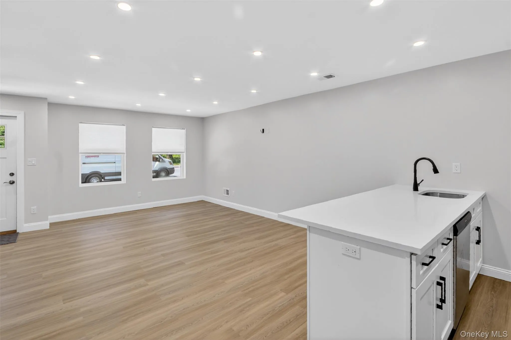 Open concept living space featuring wood-finish flooring and recessed lighting Open concept living space featuring wood-finish flooring and recessed lighting