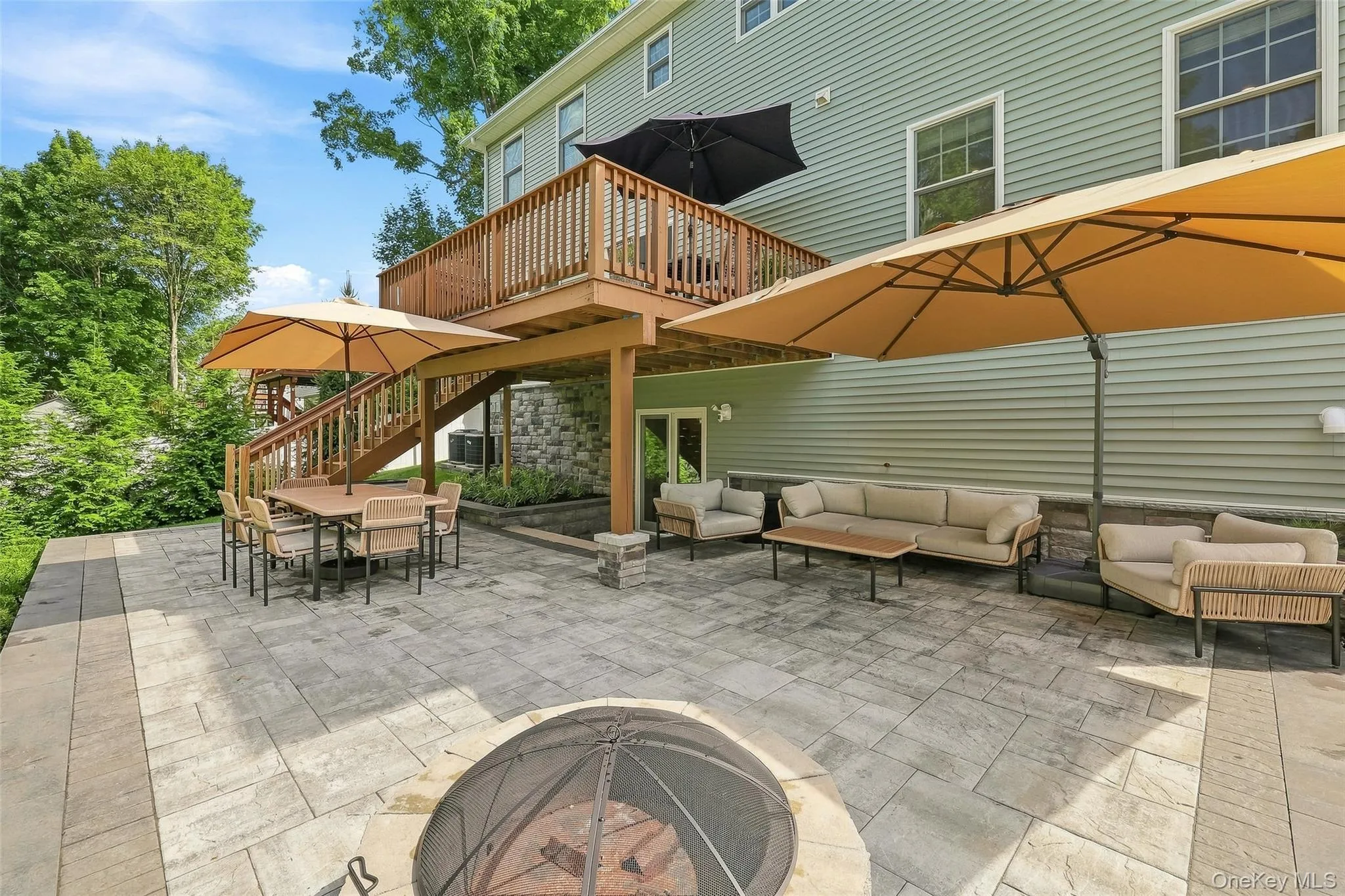 Upper level deck with stairs leading to lower level paved area Upper level deck with stairs leading to lower level paved area