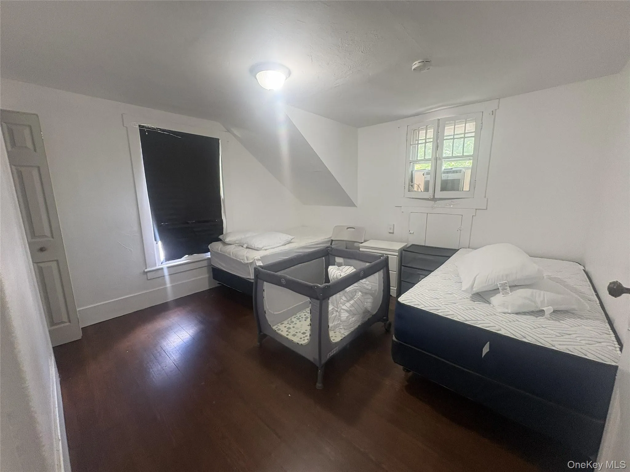 Hardwood flooring, painted interior door, window with white trim, additional window with white trim, white walls Hardwood flooring, painted interior door, window with white trim, additional window with white trim, white walls