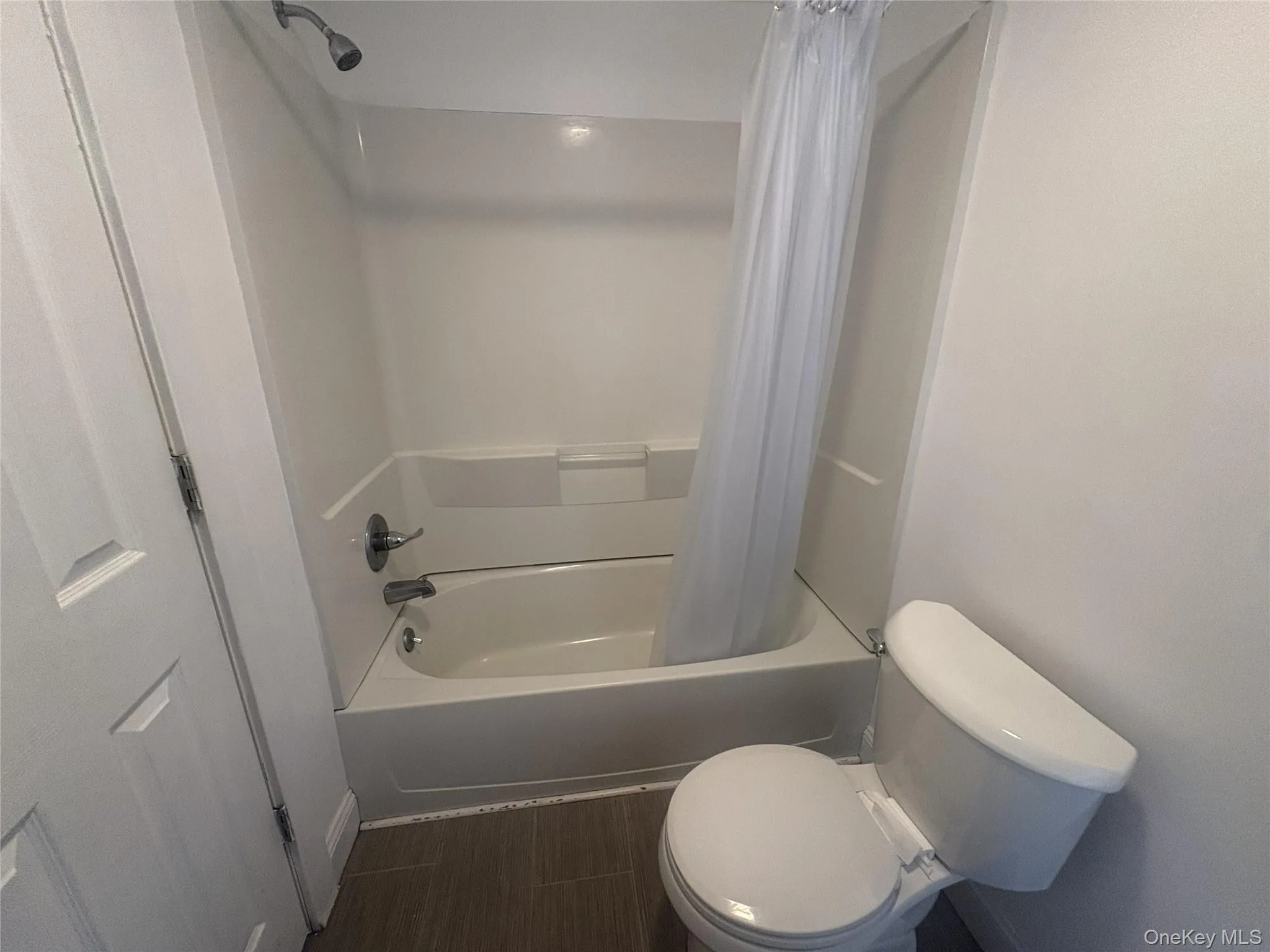 White tub and shower combination with chrome fixtures White tub and shower combination with chrome fixtures