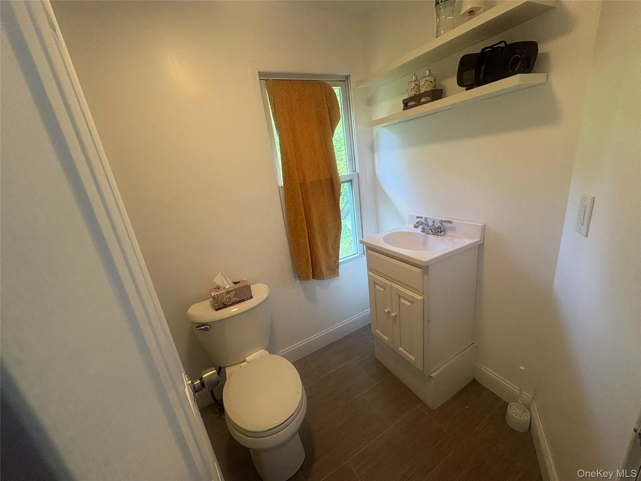 White vanity with an integrated sink and chrome faucet, accompanied by a toilet with a chrome flush lever White vanity with an integrated sink and chrome faucet, accompanied by a toilet with a chrome flush lever