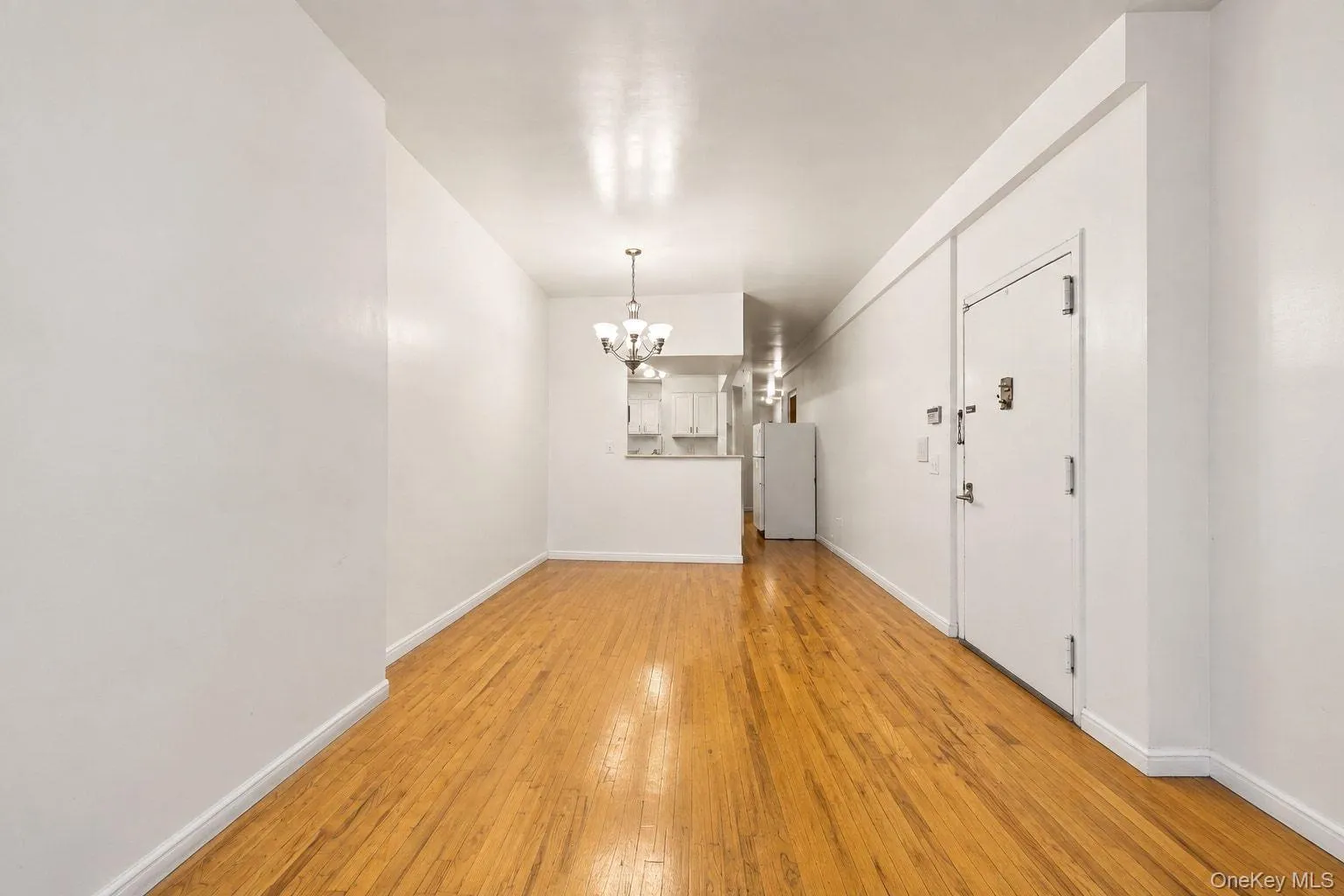Hardwood flooring, neutral wall finishes, recessed lighting, and a pendant light fixture Hardwood flooring, neutral wall finishes, recessed lighting, and a pendant light fixture