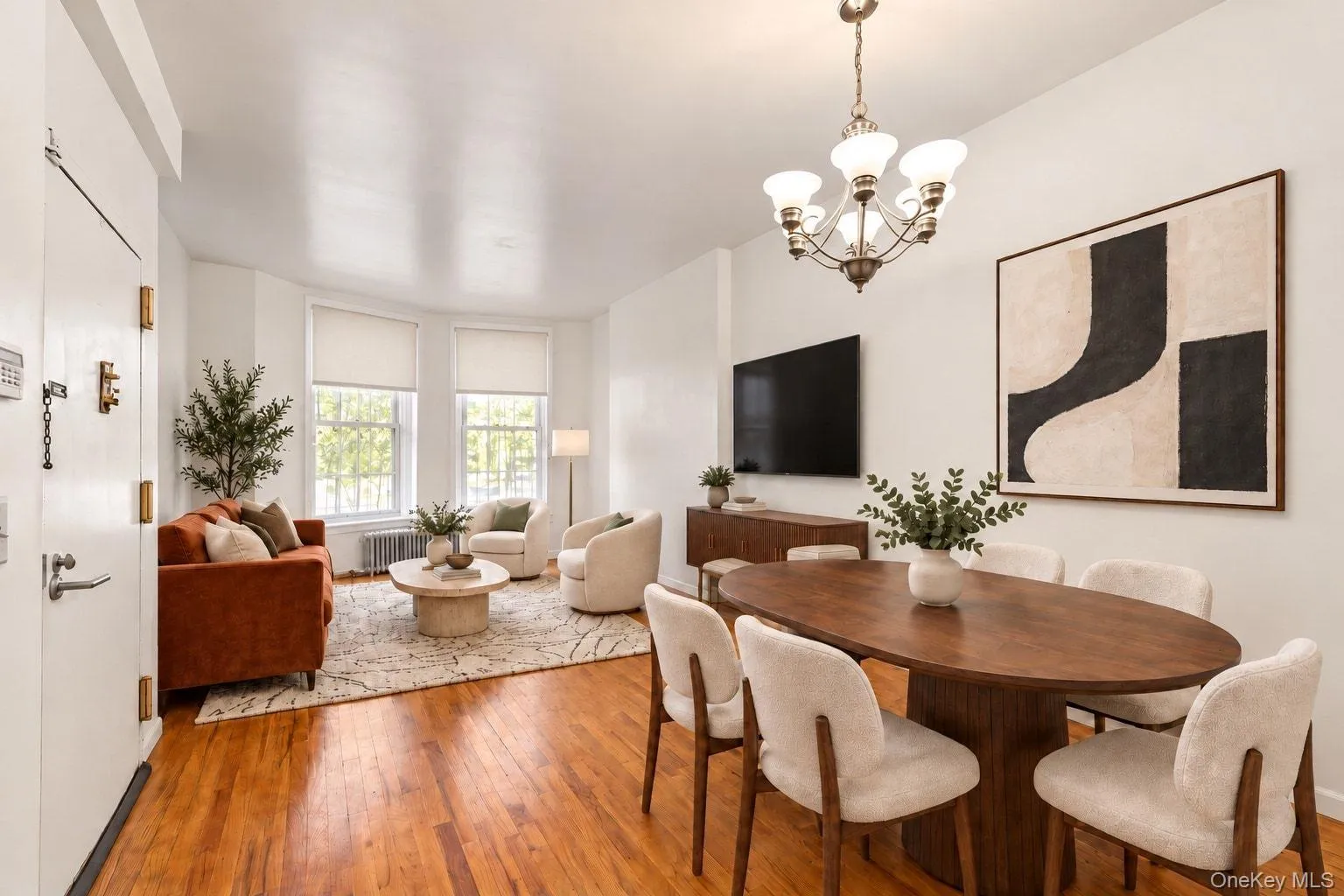 Hardwood flooring, bay windows, chandelier lighting, and a built-in media console Hardwood flooring, bay windows, chandelier lighting, and a built-in media console