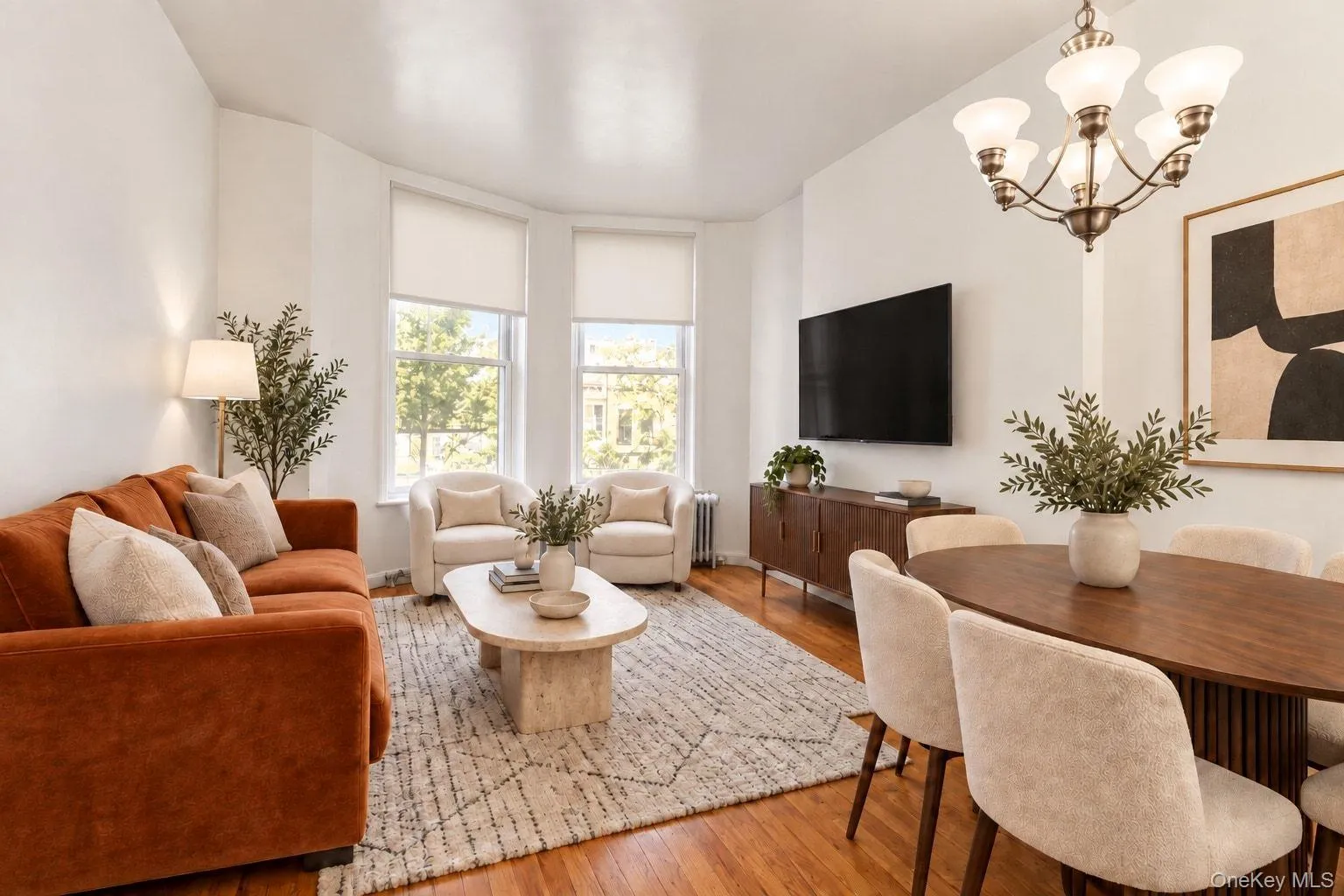 Hardwood flooring throughout, with a recessed bay window, contemporary chandelier, and built-in media console Hardwood flooring throughout, with a recessed bay window, contemporary chandelier, and built-in media console