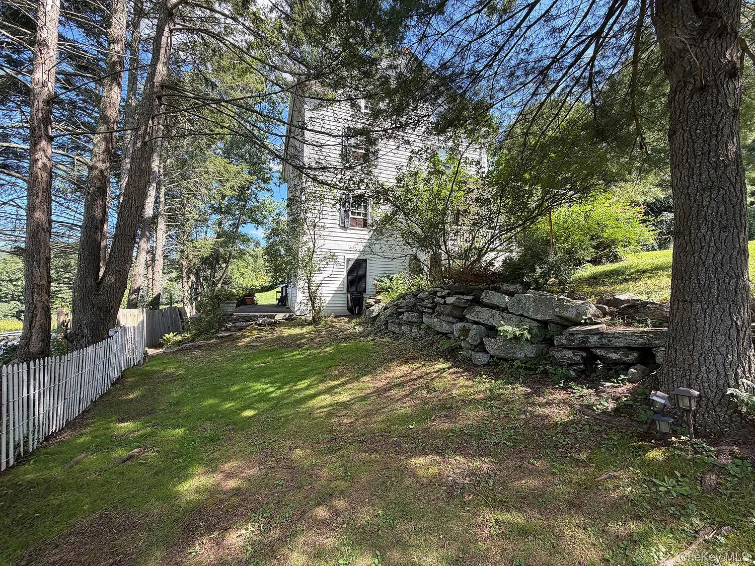 Side yard showing beautiful rock work, fence, plantings Side yard showing beautiful rock work, fence, plantings