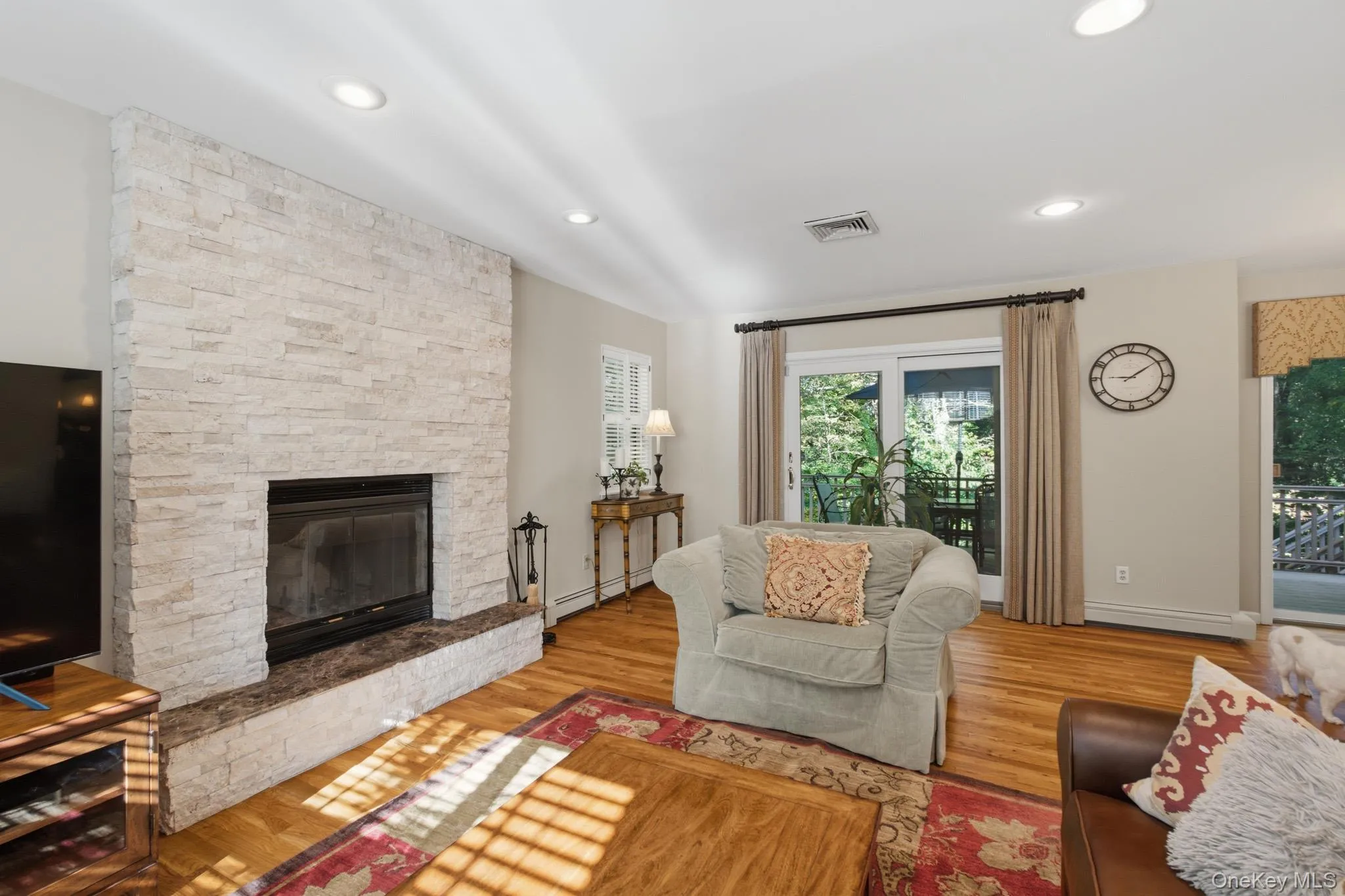 Another View of the Inviting Den, Featuring a Striking Stone-Faced Wood-Burning Fireplace and Sliding Glass Doors that Open to a Private Deck and Scenic Outdoor Surroundings. Another View of the Inviting Den, Featuring a Striking Stone-Faced Wood-Burning Fireplace and Sliding Glass Doors that Open to a Private Deck and Scenic Outdoor Surroundings.