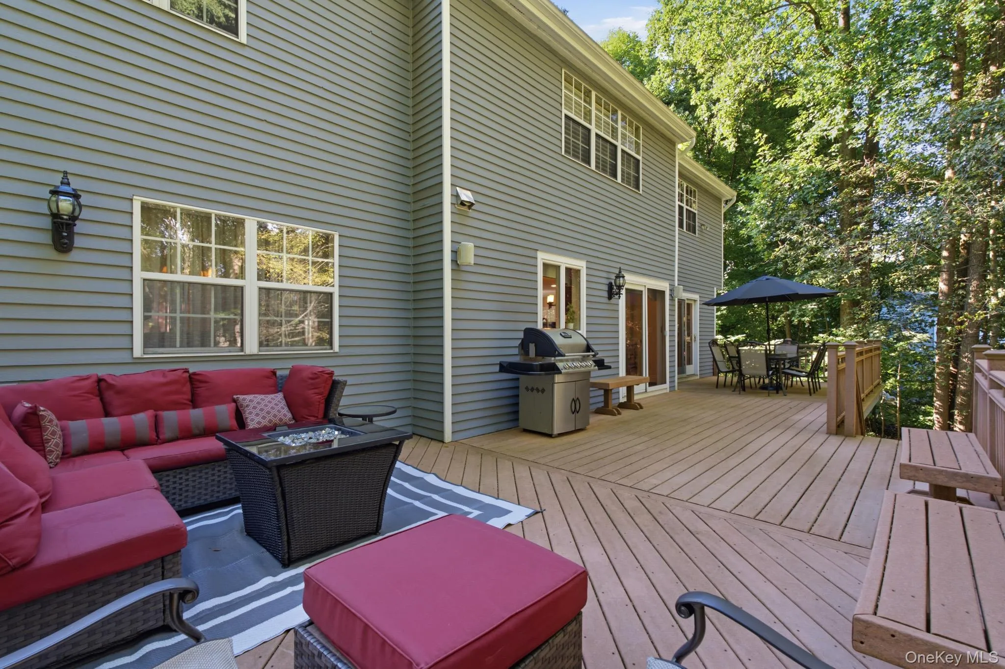 Extend your Entertaining and Relaxation Outdoors on the Expansive Trex Deck, Perfect for Outdoor Dining, Cooking, and Unwinding Amid Views of Mature Trees. Extend your Entertaining and Relaxation Outdoors on the Expansive Trex Deck, Perfect for Outdoor Dining, Cooking, and Unwinding Amid Views of Mature Trees.