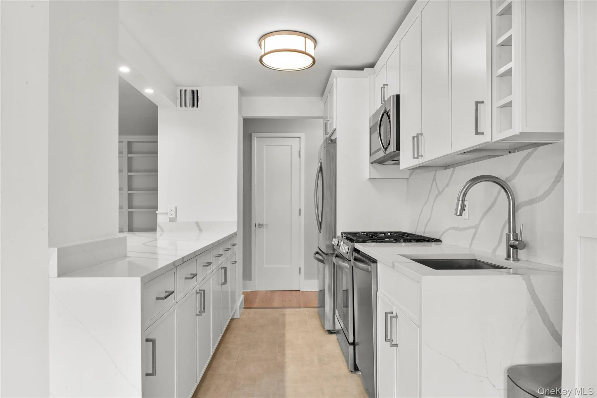 Custom white cabinetry for extensive kitchen storage Custom white cabinetry for extensive kitchen storage
