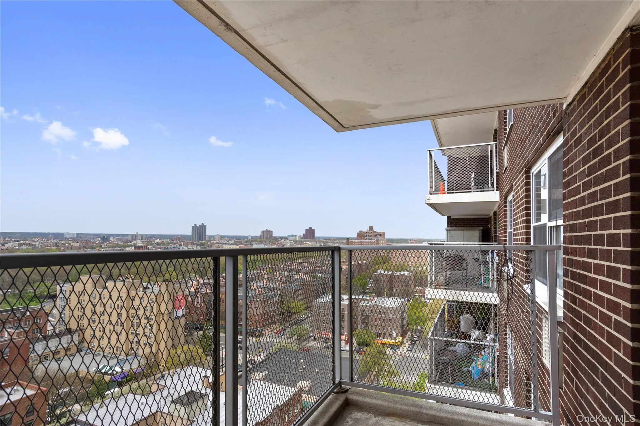 Private balcony with a metal railing, concrete flooring, and an expansive cityscape Private balcony with a metal railing, concrete flooring, and an expansive cityscape