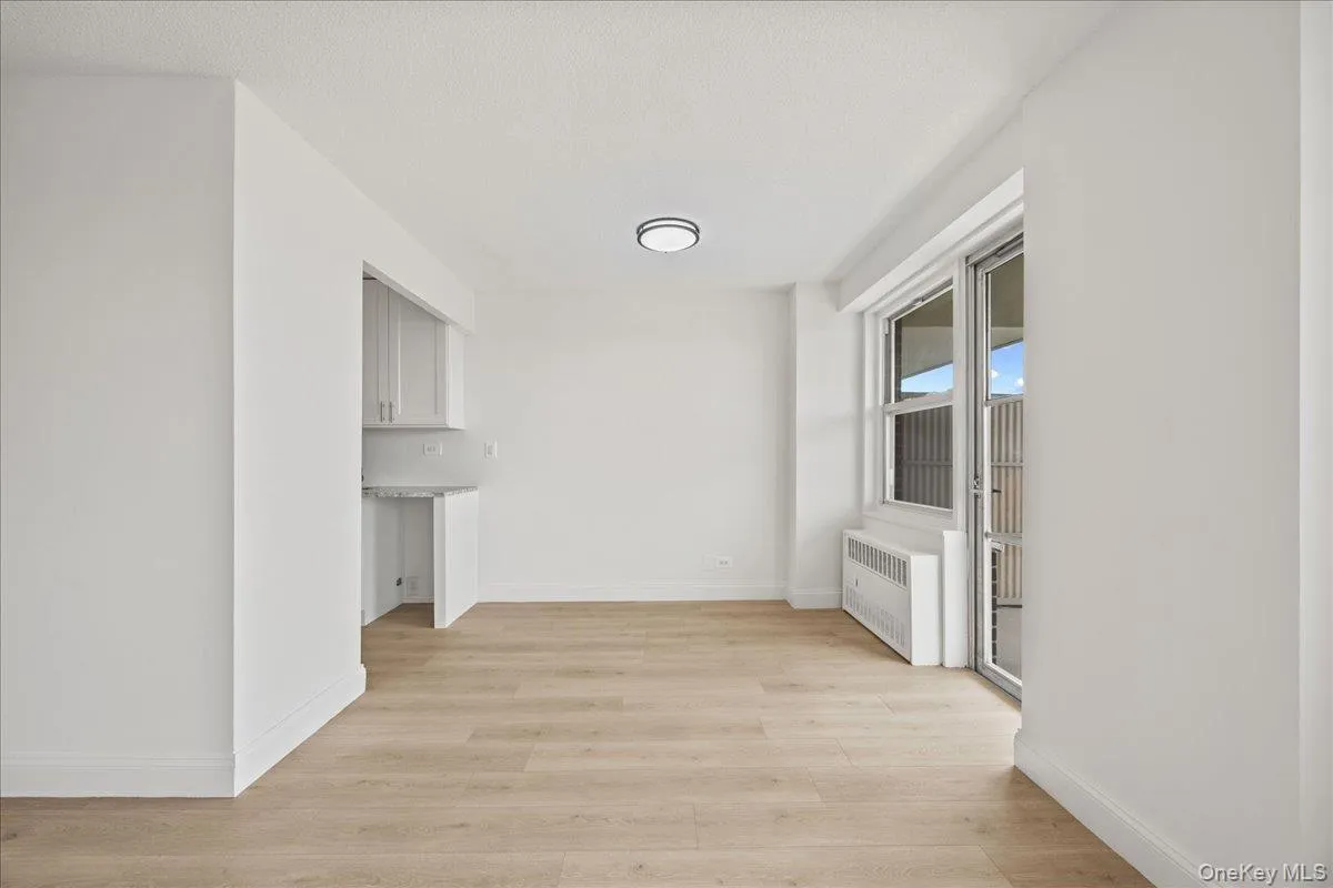 Vinyl flooring, sliding glass door with balcony access, flush-mount ceiling light fixture, and white painted walls Vinyl flooring, sliding glass door with balcony access, flush-mount ceiling light fixture, and white painted walls