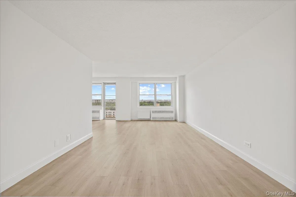 Spacious room with vinyl flooring, white walls, and multiple windows Spacious room with vinyl flooring, white walls, and multiple windows