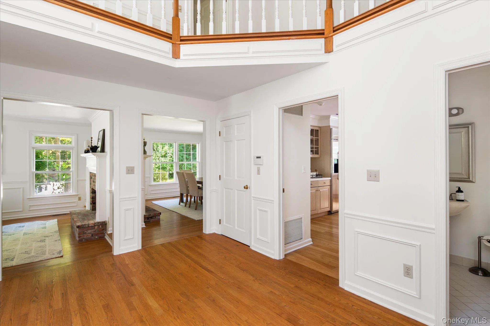 Shows living room, dining room, guest closet, door to kitchen, half bathroom and partial view of balcony Shows living room, dining room, guest closet, door to kitchen, half bathroom and partial view of balcony