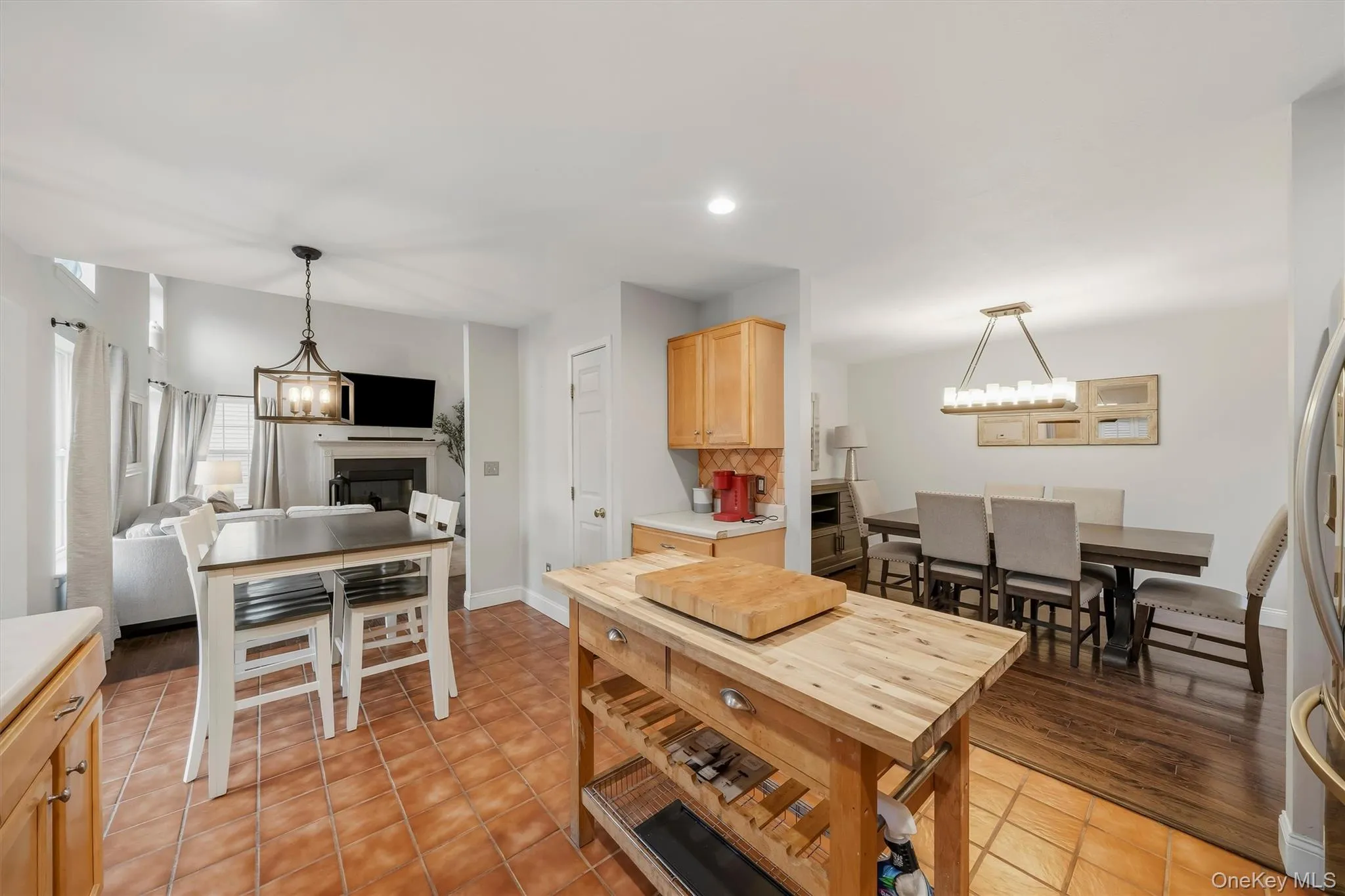Kitchen featuring terracotta tile flooring, wood cabinetry, and a movable wood-top island Kitchen featuring terracotta tile flooring, wood cabinetry, and a movable wood-top island