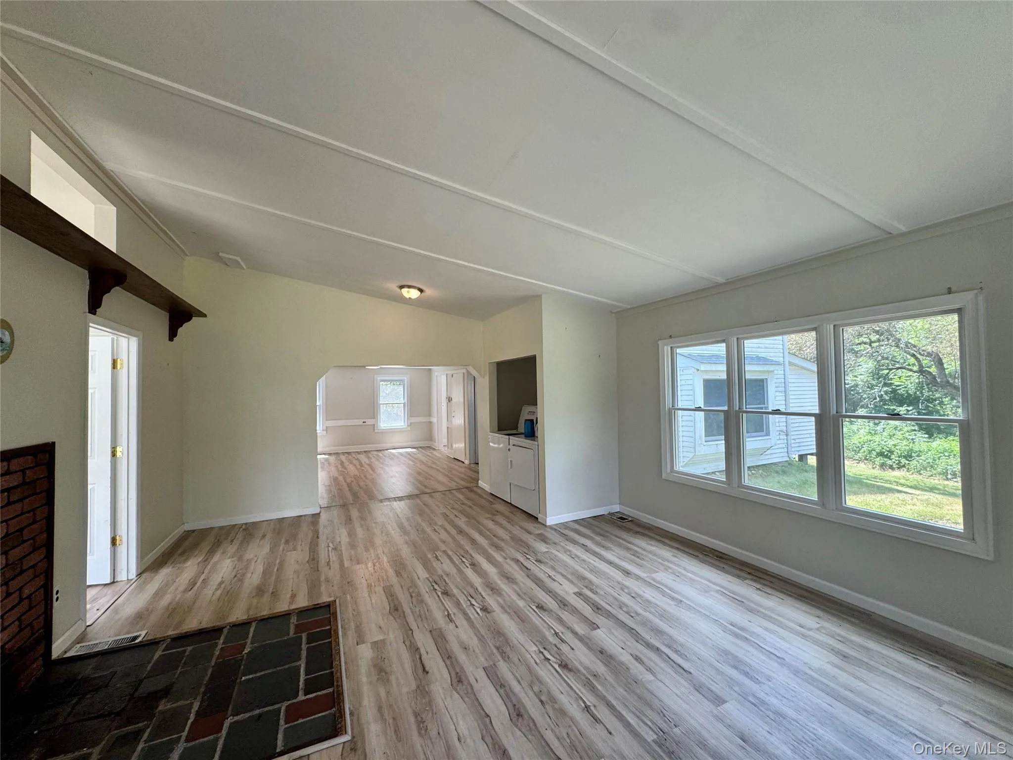 Living room with light wood-style floors and washer and dryer Living room with light wood-style floors and washer and dryer