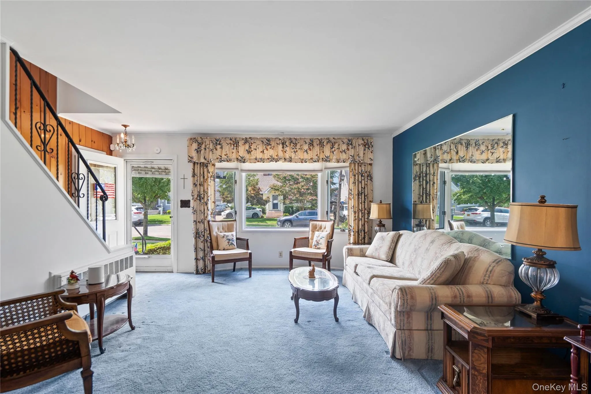Living area featuring a bay window, wall-to-wall carpeting, and a built-in radiator Living area featuring a bay window, wall-to-wall carpeting, and a built-in radiator