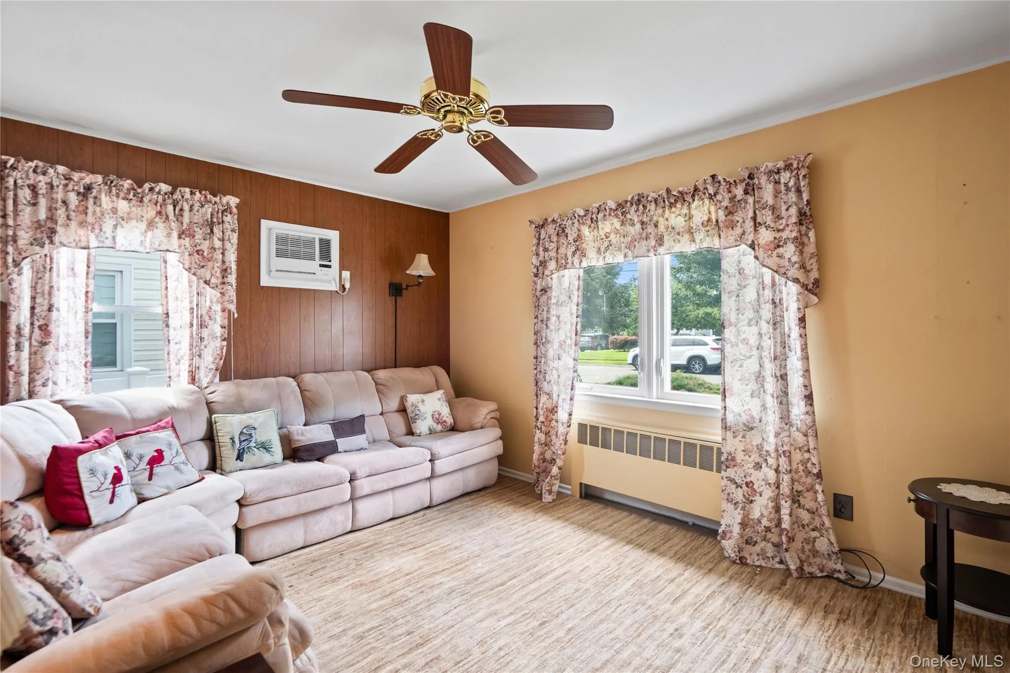 Wood-finish flooring, ceiling fan, wall-mounted air conditioning unit, and multiple windows with natural light Wood-finish flooring, ceiling fan, wall-mounted air conditioning unit, and multiple windows with natural light