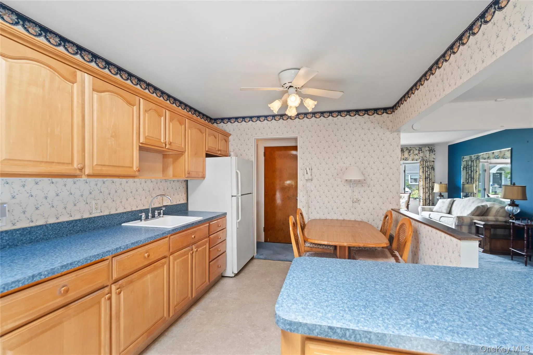 Wood-finish cabinetry paired with blue countertops and a white sink Wood-finish cabinetry paired with blue countertops and a white sink