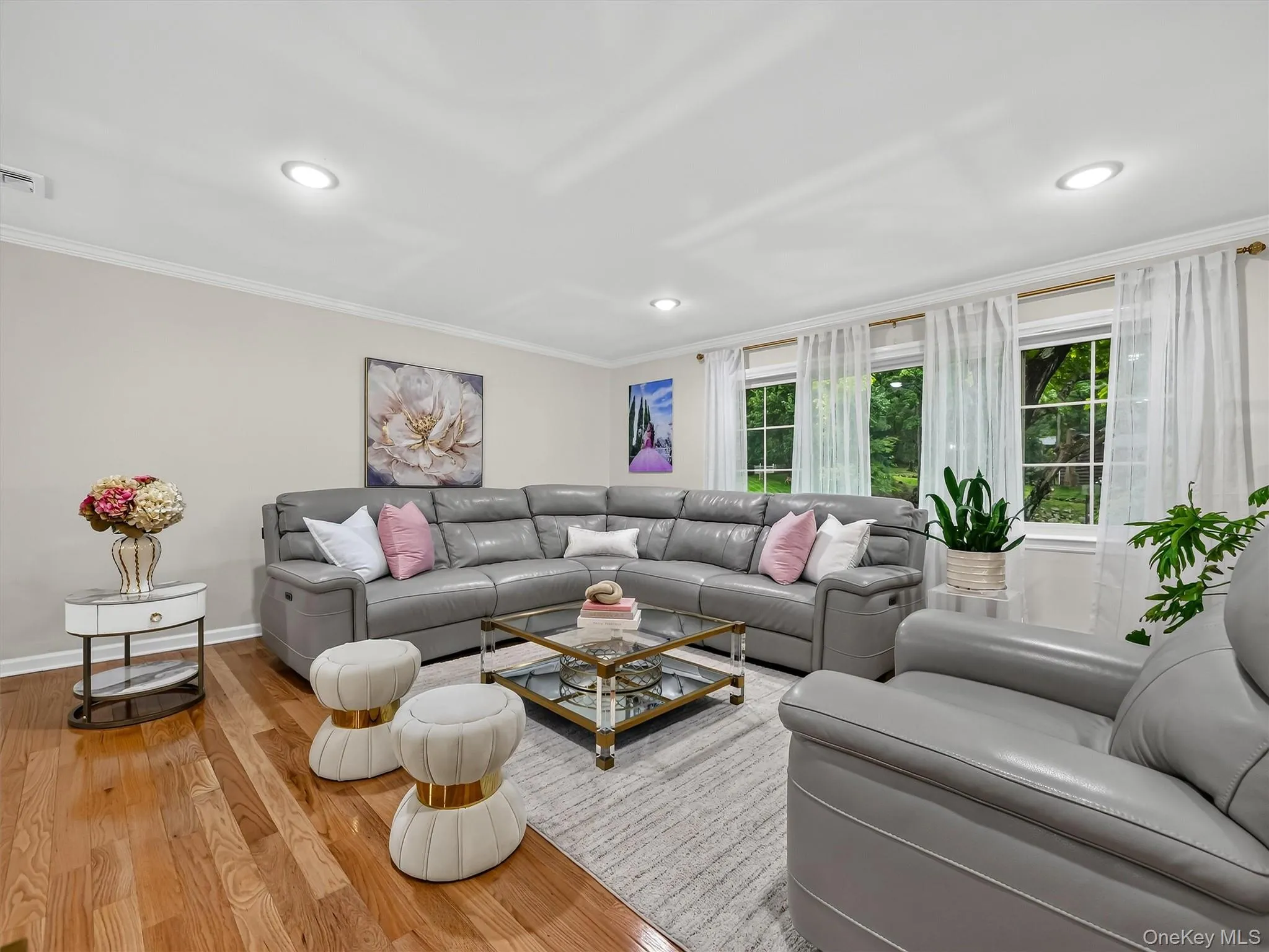 Recessed lighting illuminates the room, featuring wood-finish flooring and crown molding Recessed lighting illuminates the room, featuring wood-finish flooring and crown molding