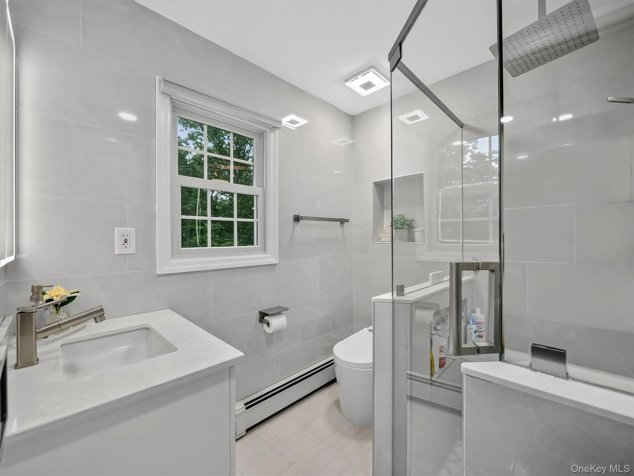 White shaker vanity with a quartz countertop and undermount sink White shaker vanity with a quartz countertop and undermount sink