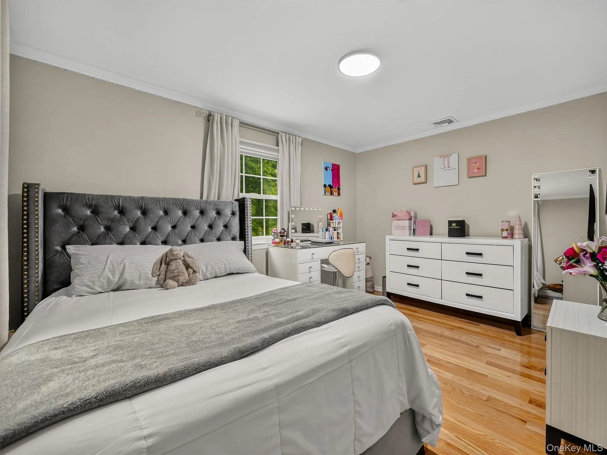 Light wood-finish flooring, neutral wall color, crown molding, and a window with natural light Light wood-finish flooring, neutral wall color, crown molding, and a window with natural light