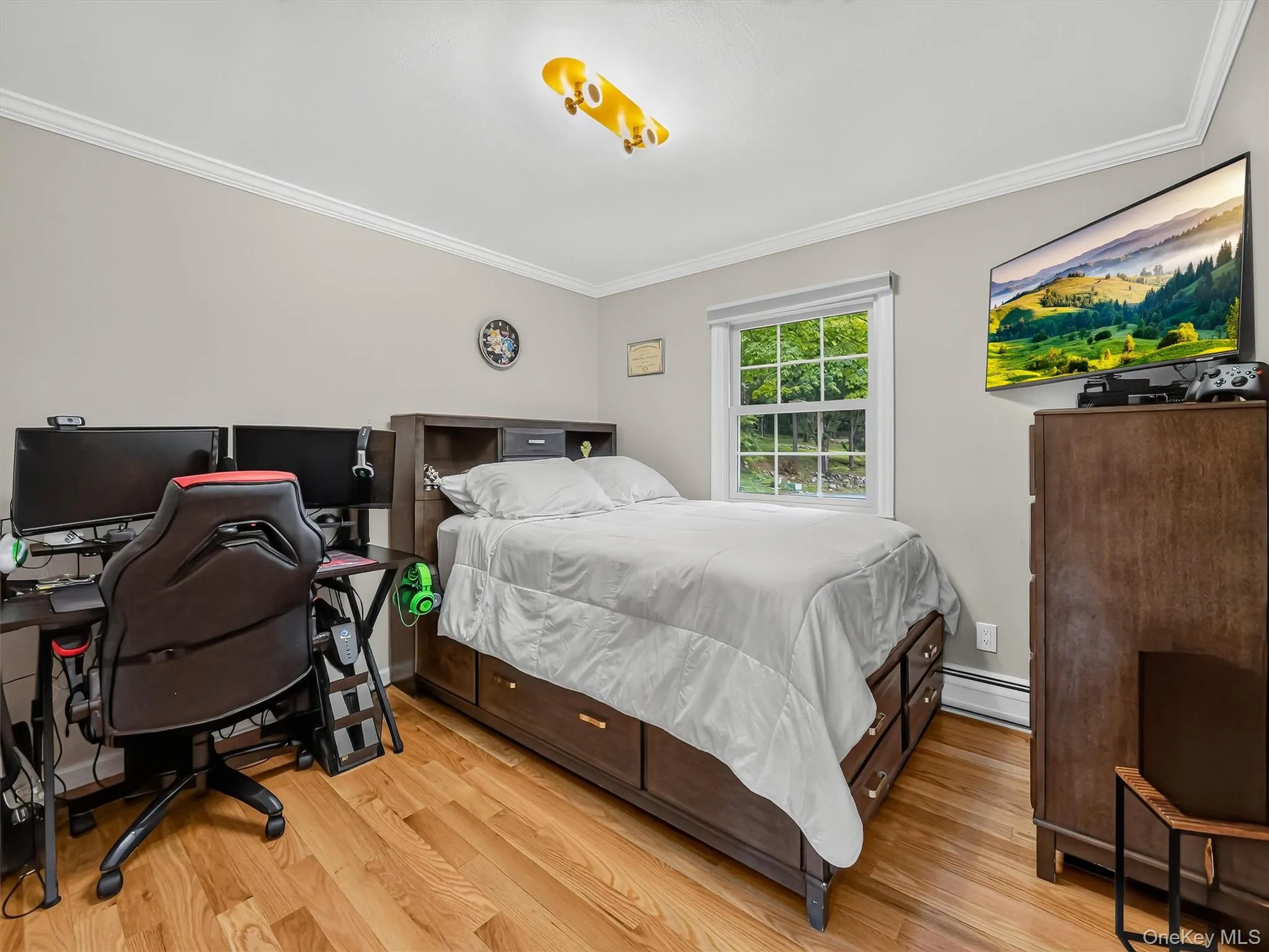 Hardwood flooring throughout, single window with natural light, crown molding, and neutral wall tones Hardwood flooring throughout, single window with natural light, crown molding, and neutral wall tones