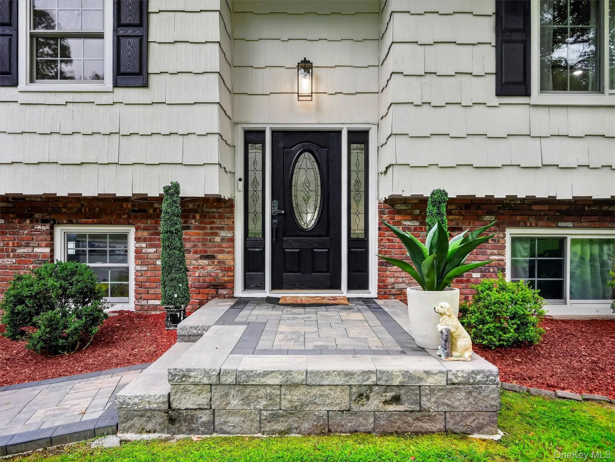 Paver walkway leading to a multi-level paver entrance with a decorative retaining wall Paver walkway leading to a multi-level paver entrance with a decorative retaining wall